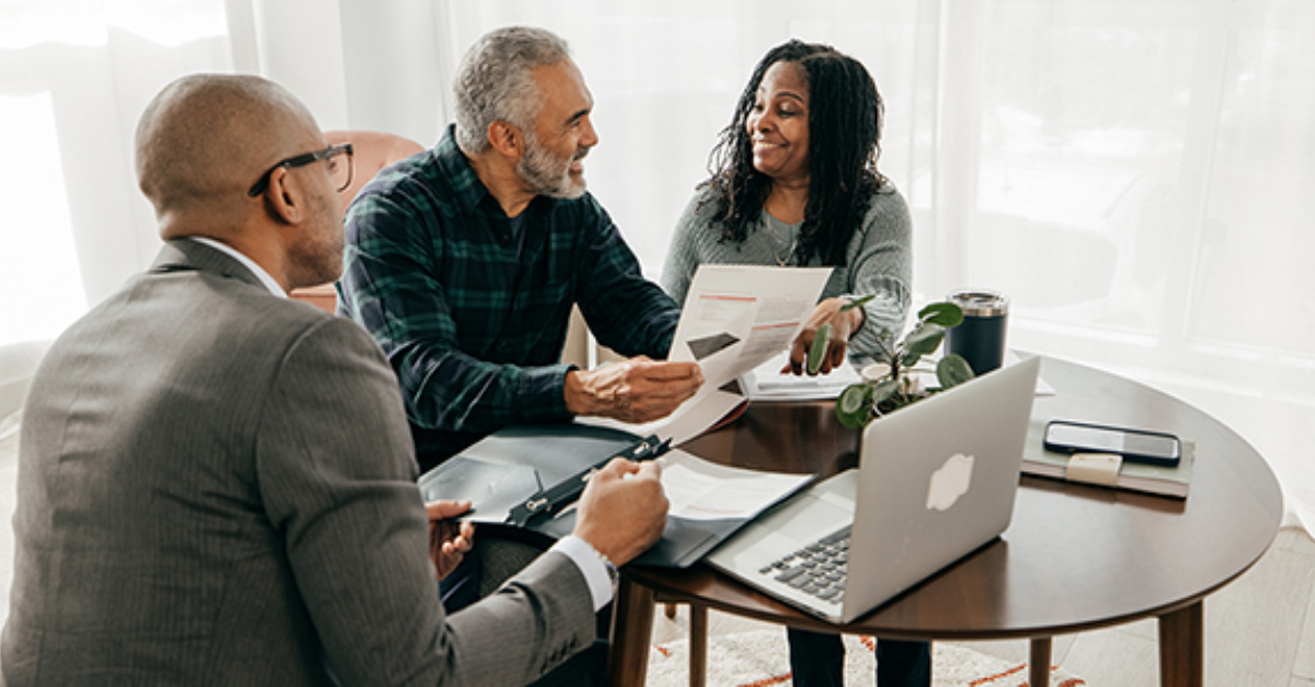 Agent with home buyers at table